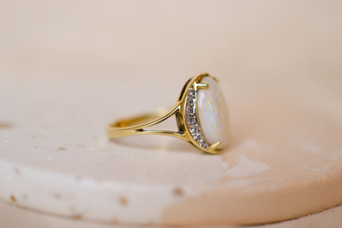 Bague Vintage en Or jaune 18 carats centrée d'une Opale épaulée par des lignes de Diamants