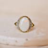 Bague ancienne en Or jaune 18 carats sertie griffes d'une Opale épaulée par des lignes de Diamants