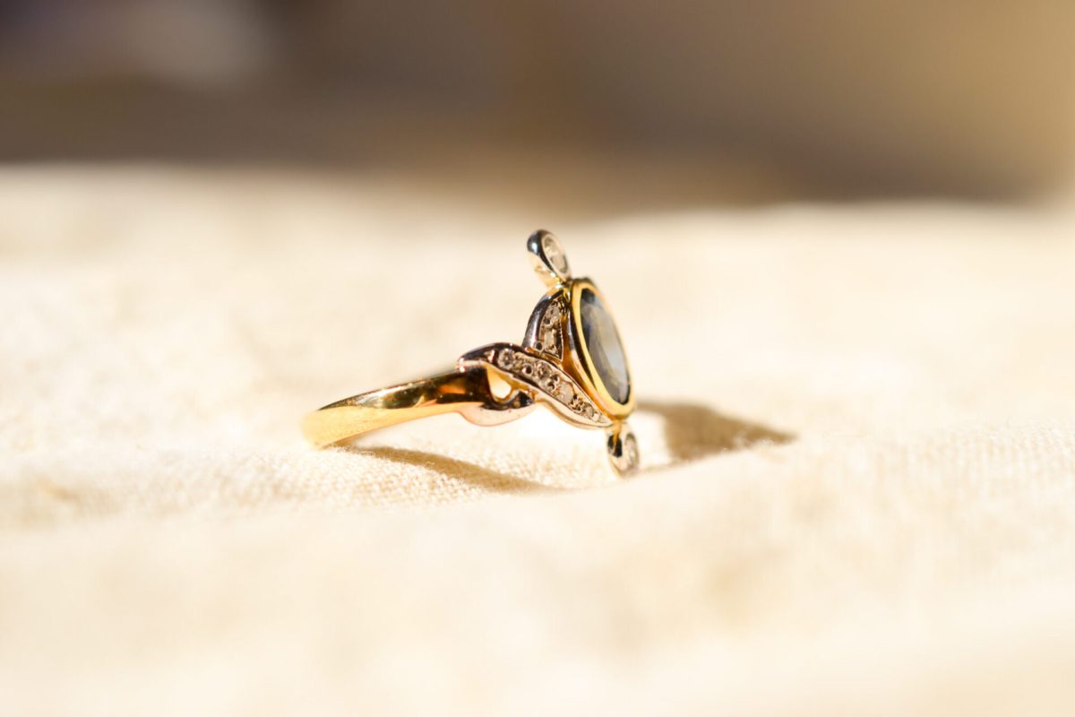 Bague Vintage en Or jaune 18 carats centrée d'un Saphir dans un entourage de Diamants