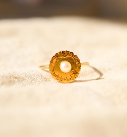 Bague circulaire ornée d'une Perle sur un plateau ciselé à bords festonnés