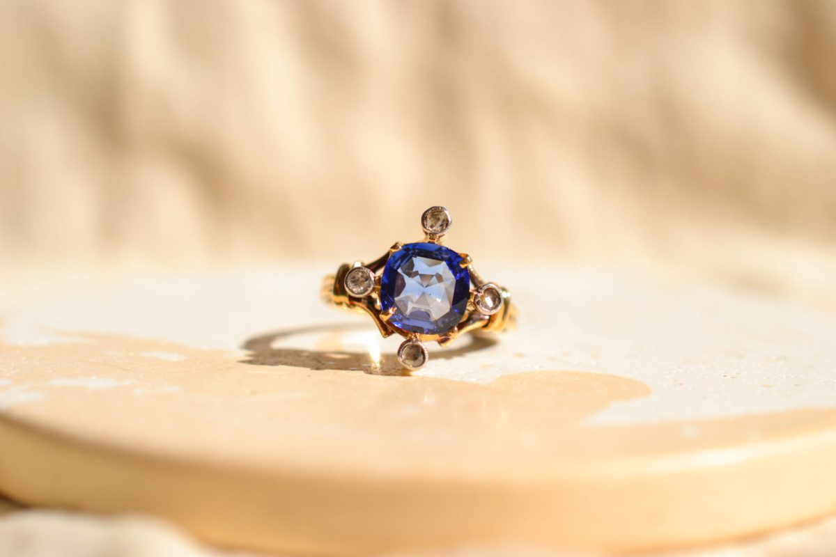 Bague ancienne en Or jaune 18 carats centrée d'un Saphir de synthèse entouré de Diamants