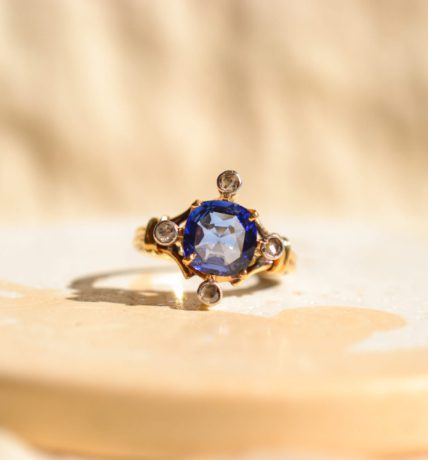 Bague ancienne en Or jaune 18 carats centrée d'un Saphir de synthèse entouré de Diamants