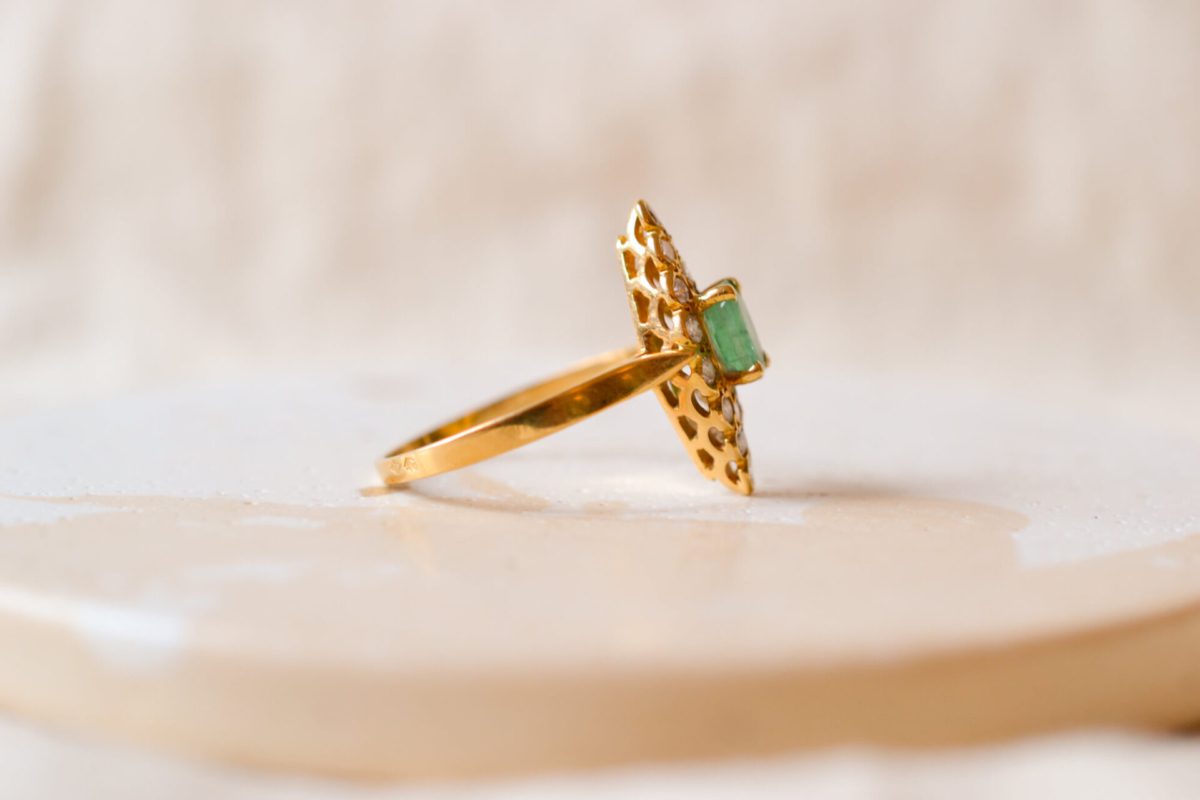 Bague ancienne en Or jaune 18 carats centrée d'une Emeraude entourée de Diamants