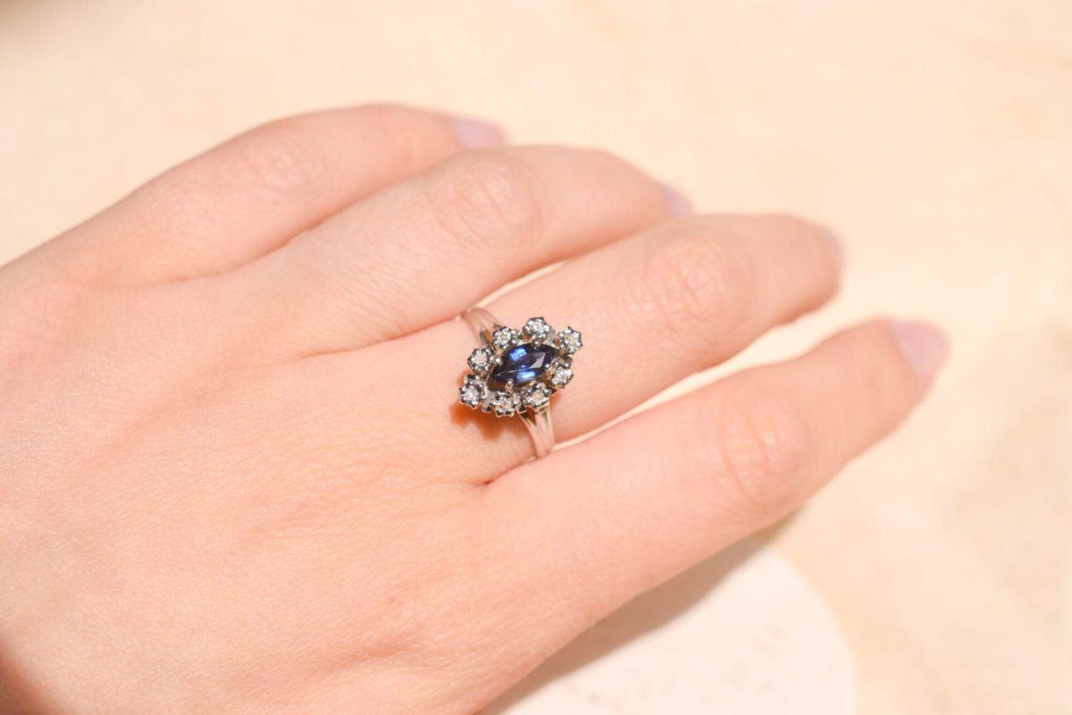 Bague de fiançailles ancienne en Or blanc 18 carats centrée d'un Saphir entouré de Diamants