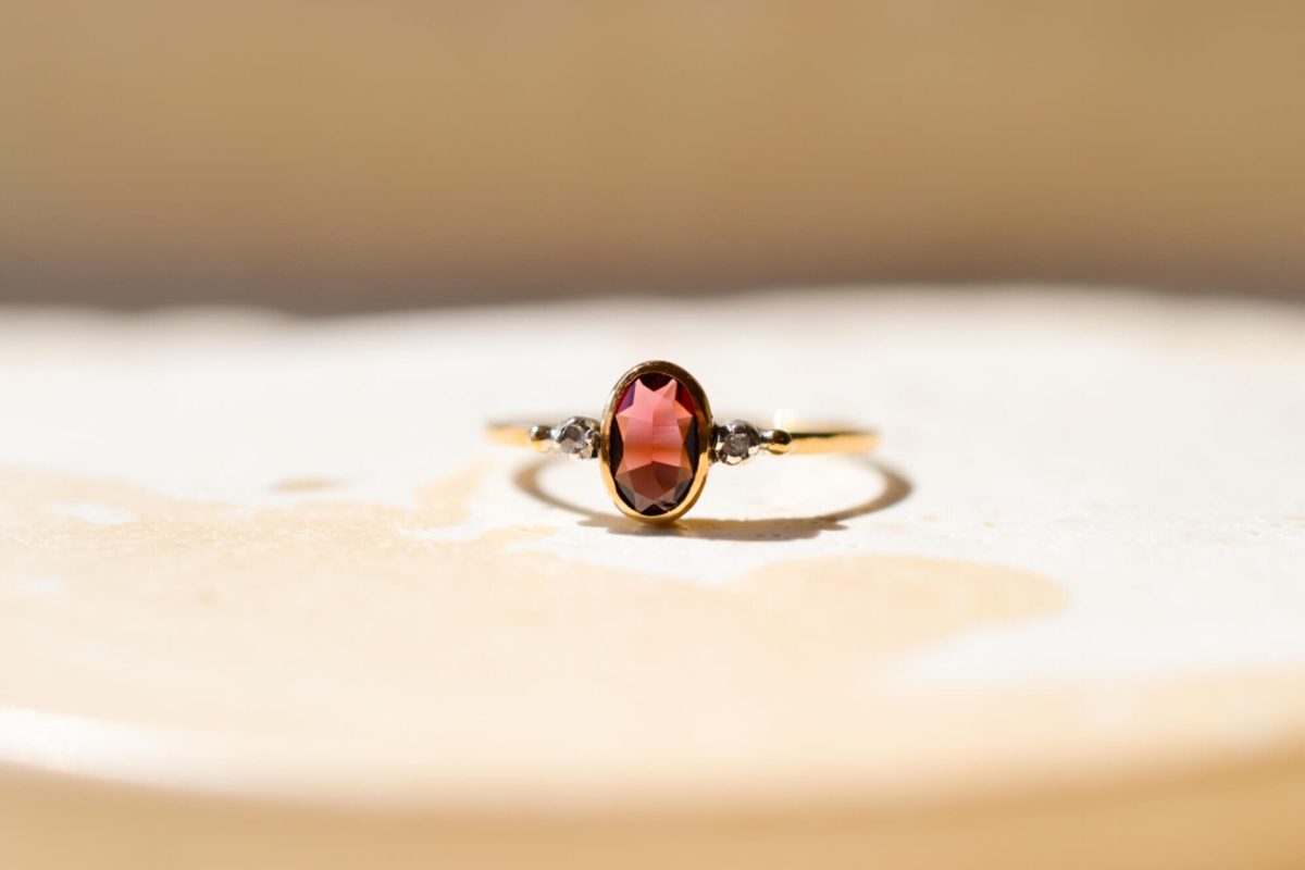 Bague ancienne en Or jaune 18 carats centrée d'un Grenat Almandin épaulé par 2 Diamants