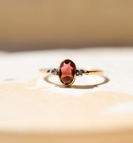 Bague ancienne en Or jaune 18 carats centrée d'un Grenat Almandin épaulé par 2 Diamants
