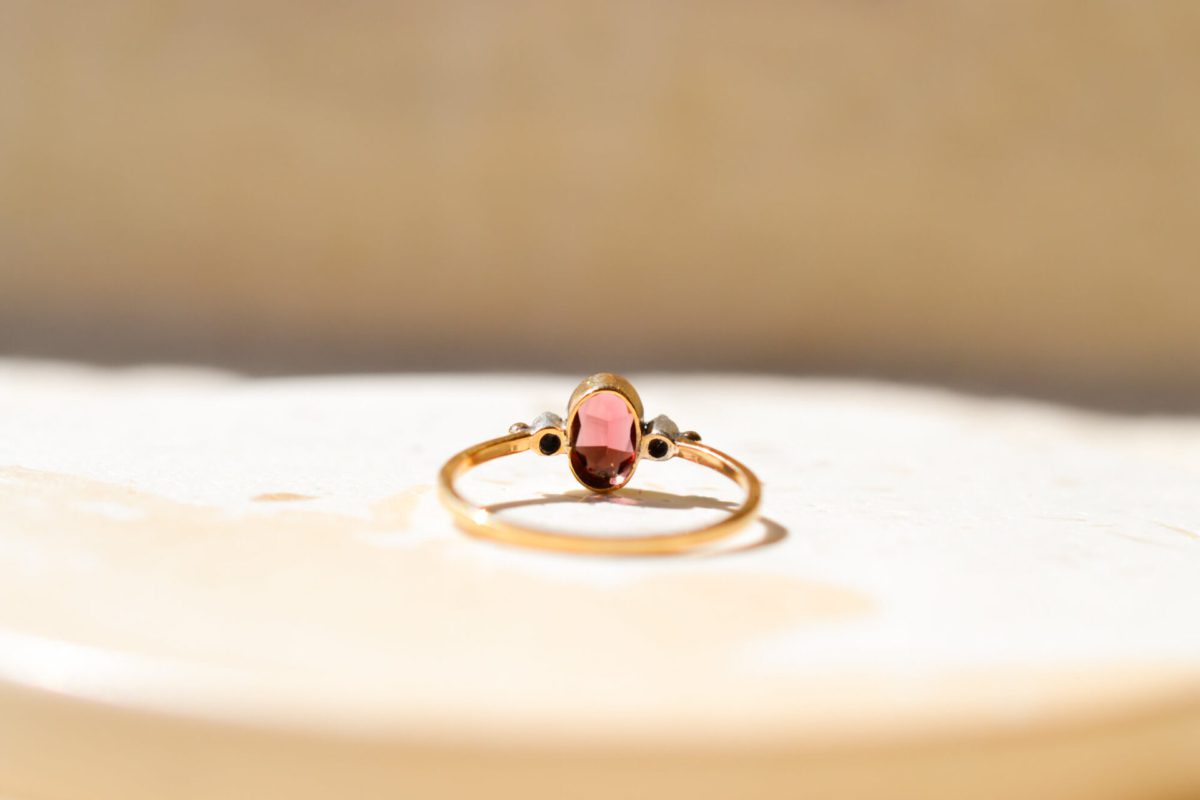 Bague en Or jaune 18 carats centrée d'un Grenat Almandin épaulé par 2 Diamants