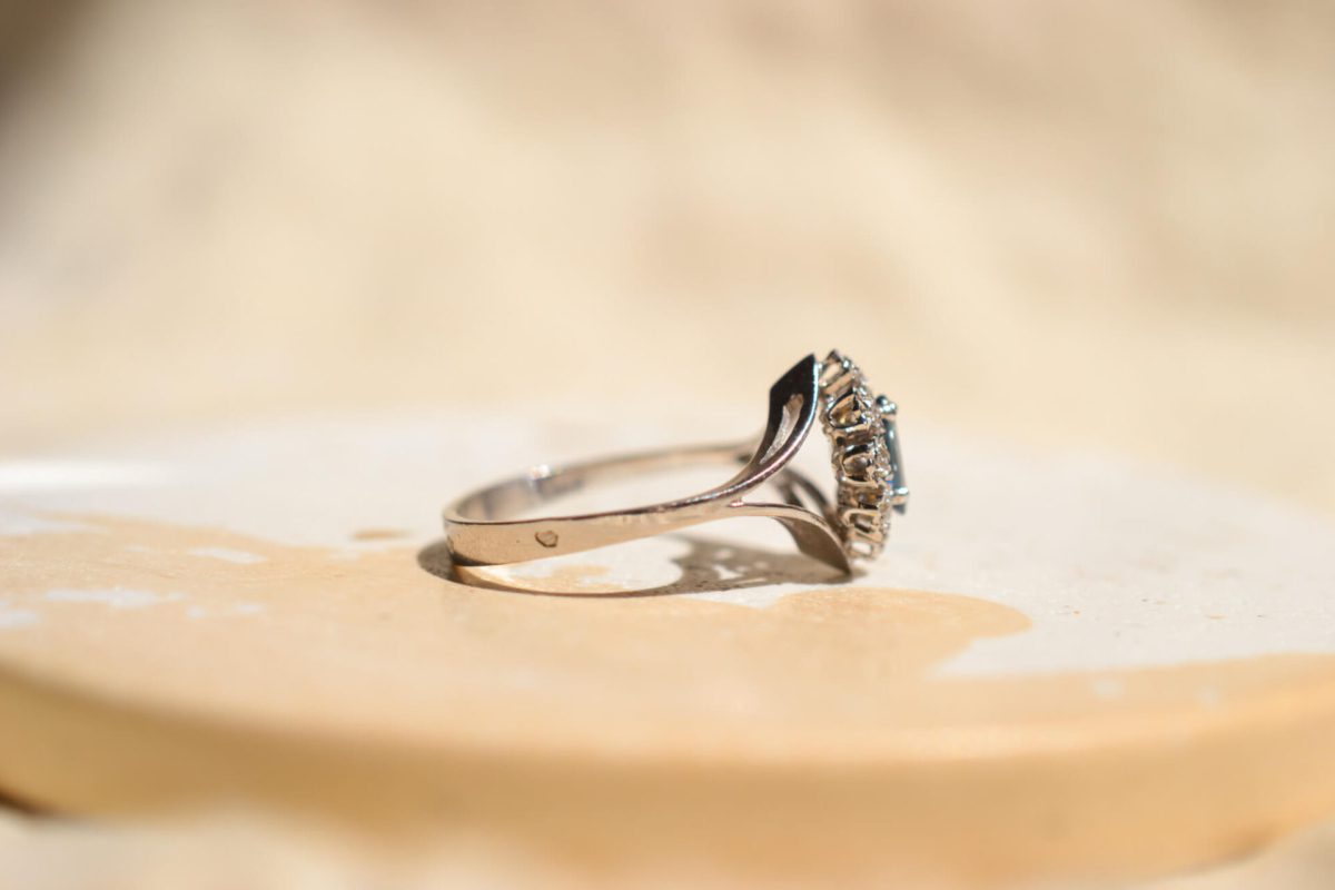 Bague ancienne en Or blanc 18 carats centrée d'un Saphir entouré de Diamants