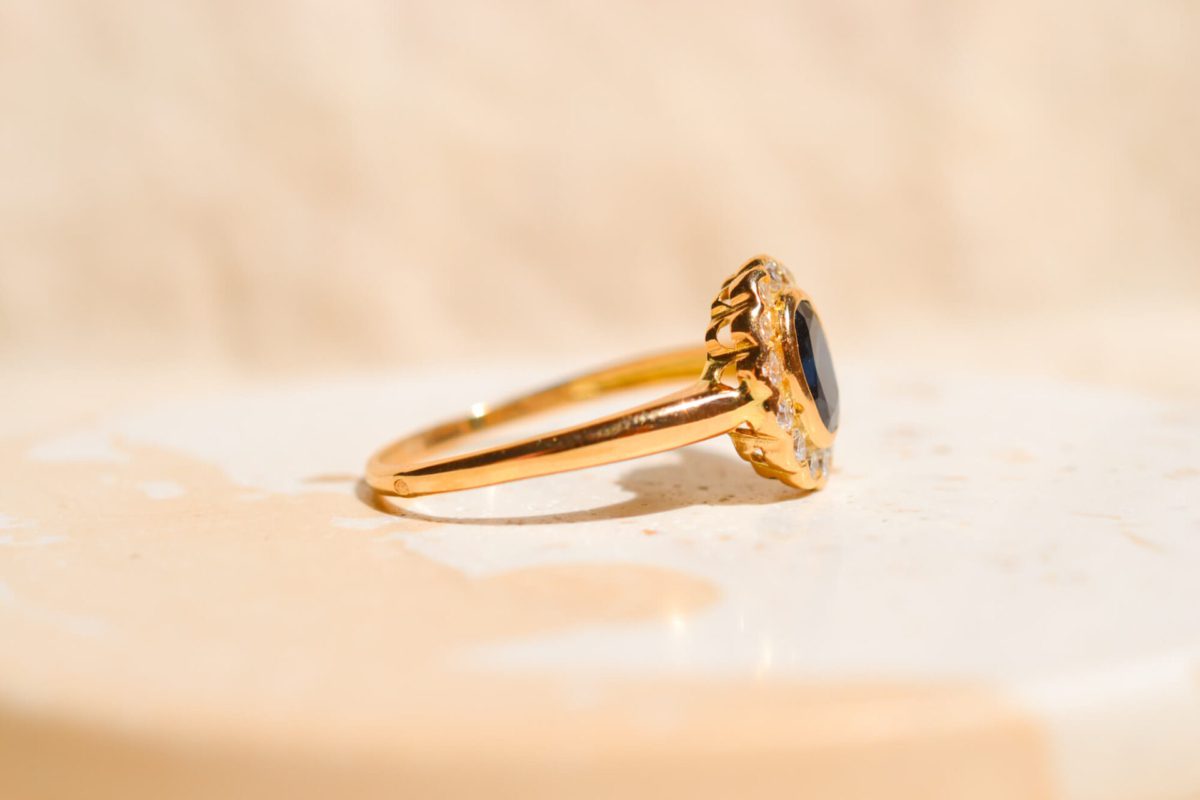 Bague Marguerite ancienne en Or jaune 18 carats centrée d'un Saphir entouré d'un Diamant