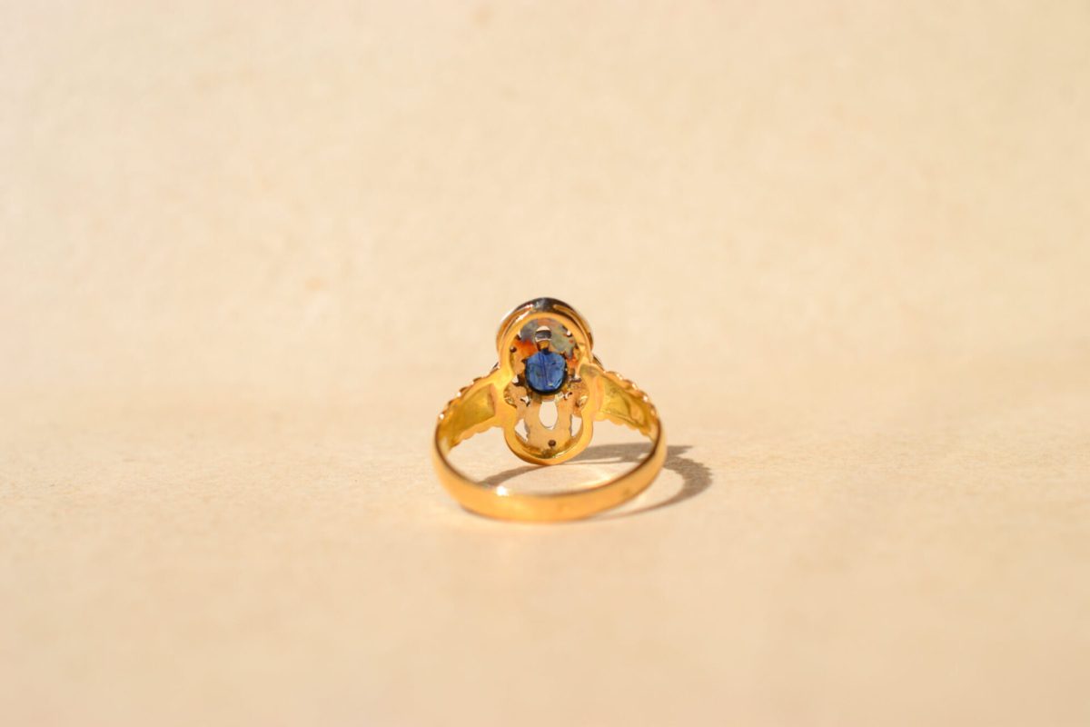 Bague ancienne en Or jaune 18 carats centrée d'un Saphir entouré de Diamants